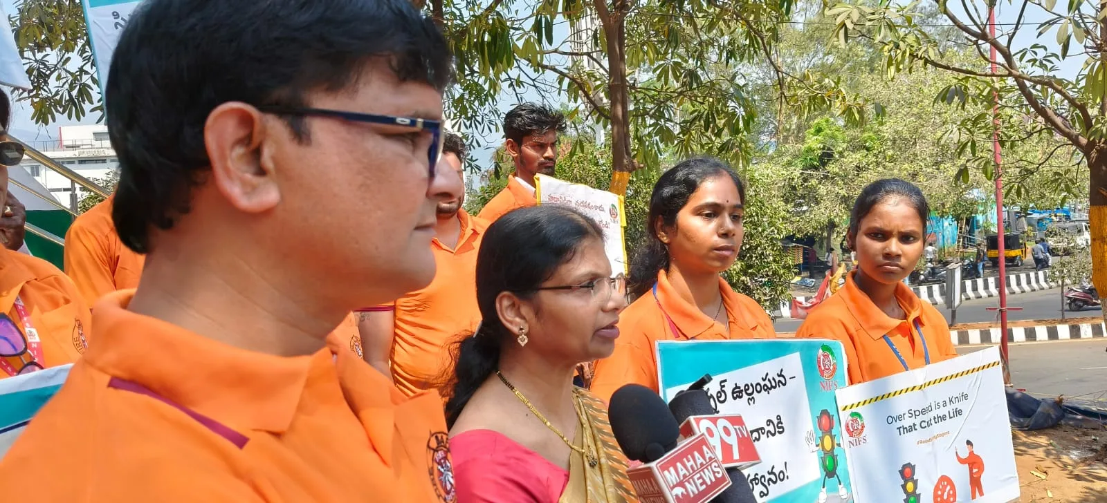 Road safety awareness rally participants with local news microphones